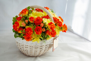 Flowers bunch wicker basket, with red roses and yellow chrysanthemums in gift box