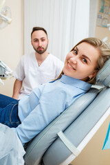 Obraz premium A professional dentist communicates with a woman patient. Dental office for patient examination. Discussion of the dental treatment process.