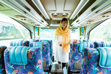 asian muslim woman doing eid mubarak traveling back to her hometown by riding a bus