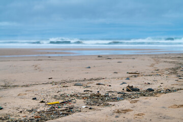 Plastic and micro plastic garbage washing on a beach during the low tide at a beach in Southern...