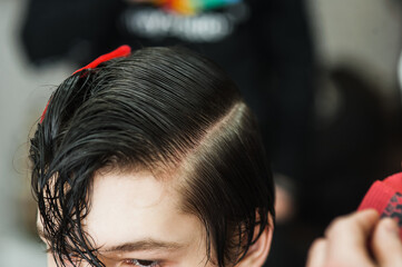 Hipster client man visiting in barber shop shaving hair. Modern guy having his hair cut in...