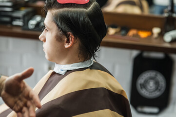 Hipster client man visiting in barber shop shaving hair. Modern guy having his hair cut in...