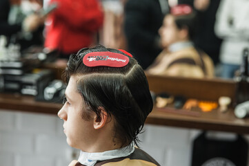 Hipster client man visiting in barber shop shaving hair. Modern guy having his hair cut in...