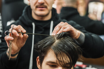 Hipster client man visiting in barber shop shaving hair. Modern guy having his hair cut in...