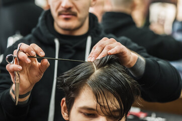 Hipster client man visiting in barber shop shaving hair. Modern guy having his hair cut in...