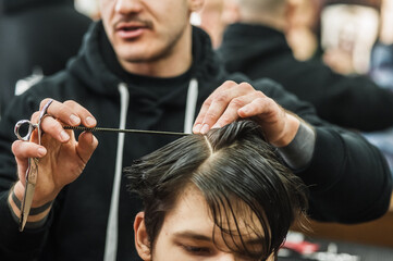 Hipster client man visiting in barber shop shaving hair. Modern guy having his hair cut in...