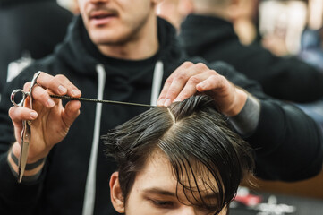 Hipster client man visiting in barber shop shaving hair. Modern guy having his hair cut in...