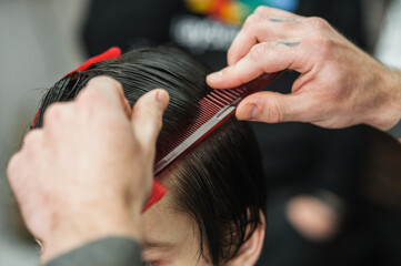 A man in a barbershop.Modern guy having his hair cut in barbershop