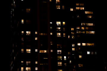 immeuble la nuit aux fenêtres allumées