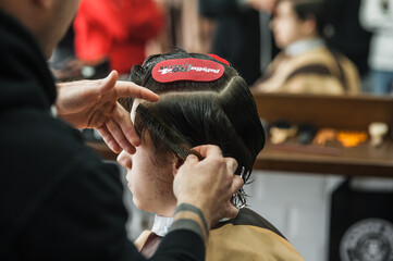 A man in a barbershop.Modern guy having his hair cut in barbershop