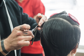 A man in a barbershop.Modern guy having his hair cut in barbershop