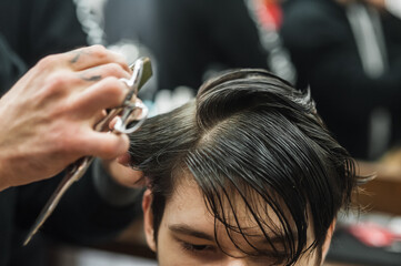 A man in a barbershop.Modern guy having his hair cut in barbershop