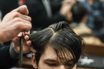 Obraz premium A man in a barbershop.Modern guy having his hair cut in barbershop