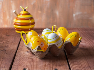 Easter picture with painted eggs and a jar of yellow honey