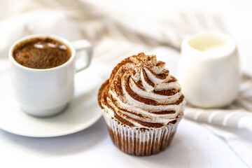Black coffee with cupcakes and muffins. Spice cupcakes with creamcheese frosting decorated with a cocoa