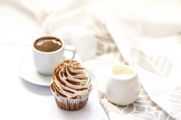 Black coffee with cupcakes and muffins. Spice cupcakes with creamcheese frosting decorated with a cocoa