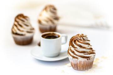 Black coffee with cupcakes and muffins. Spice cupcakes with creamcheese frosting decorated with a cocoa