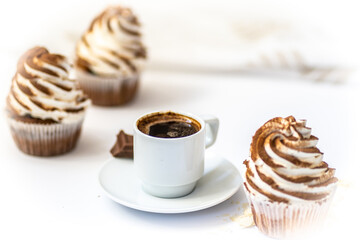 Black coffee with cupcakes and muffins. Spice cupcakes with creamcheese frosting decorated with a cocoa