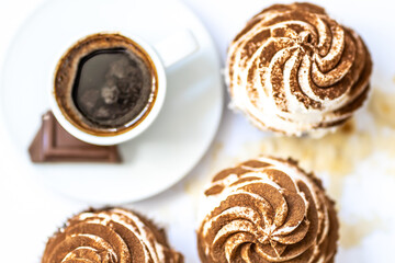 Black coffee with cupcakes and muffins. Spice cupcakes with creamcheese frosting decorated with a cocoa