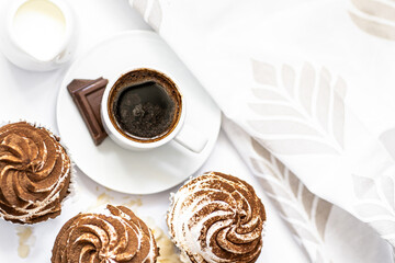 Dark chocolate and cocoa chocolate cupcakes with a cup of hot black coffee. Space for text