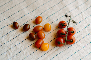 Fresh and organic cherry tomatoes on a rustic white tablecloth.Top view 