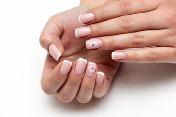 French manicure with snowflakes and sparkles. Gel nail design close up on white background