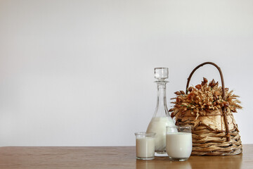 Horizontal white copyspace with milk bottle and glasses, and flower basket