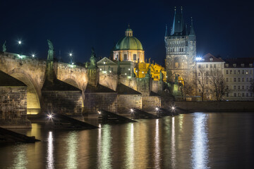 Fototapeta na wymiar Scenic view on Vltava river, Charles bridge and historical center of Prague, buildings and landmarks of old town at sunrise or dusk, Prague, Czech Republic. Beautiful gothic buildings.