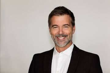 Portrait Of A Mature Man Smiling At The Camera. He is a CEO. Good looking businessman. Isolated on white.