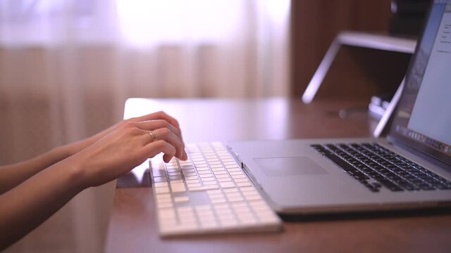 Female hands of business woman professional user worker using typing on laptop notebook keyboard sit at home office desk working online with pc software apps technology concept, close up side view