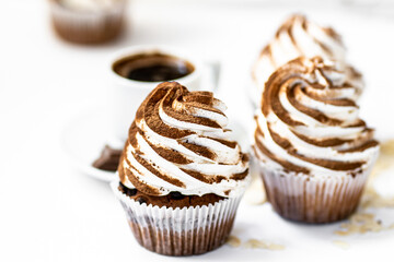 Black coffee with cupcakes and muffins. Spice cupcakes with creamcheese frosting decorated with a cocoa