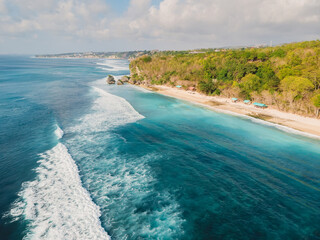 Aerial view of waves in ocean and coastline with Thomas beach in Bali island
