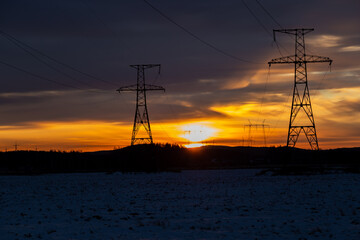 Electricity pylons at orange sunset