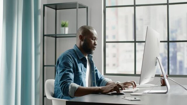 African american freelancer types text on computer in office