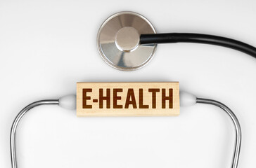 On the table is a stethoscope and a wooden plate with the inscription - e-health
