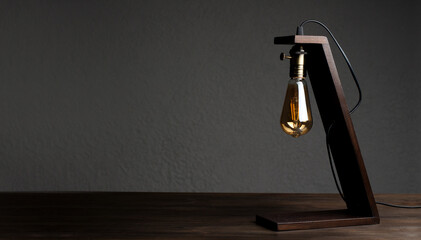 Table lamp on the table. Wooden decorative lamp. Night light in the dark.