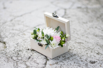 Close up of a wood box with white and pink flowers.