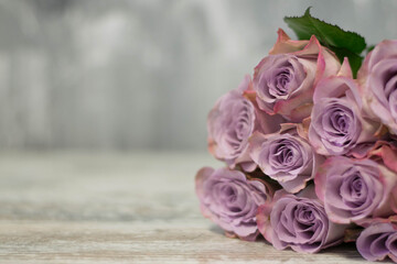 Bunch of delicate purple roses on grey background. Romantic shabby chic decor.