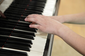 Obraz premium Russian piano girl white hands playing on the classical piano close-up, kids learning for music playing in the school
