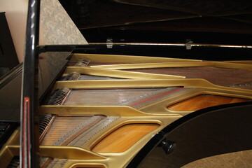 Obraz na płótnie Canvas Classic Grand Piano inside view with Gold frame strings and pegs under opened cover , classical music equipment