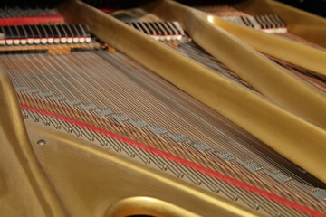 Old classic Grand Piano inside view with strings and frame close up under opened cap , musical instruments repair