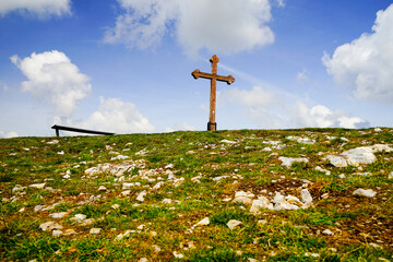 Pilgrimage cross with stone and gras ground on a cloudy day