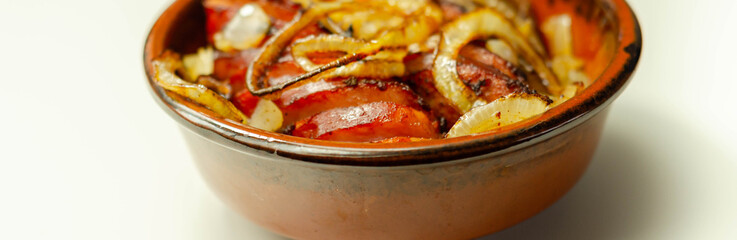Traditionally roasted German sausage with onion served in a ceramic bowl