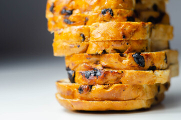 Fruit loaf with sultanas and orange flavored pieces on the white background