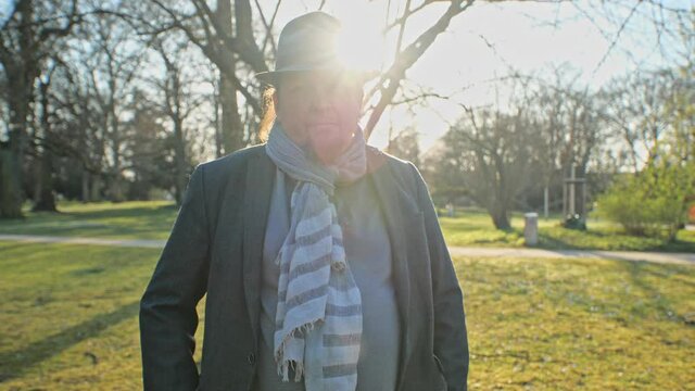 [4k] selfassured man with scarf and hat looking in soft back light