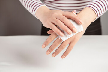 Woman cleaning hand with napkin