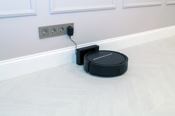 Robotic Vacuum Cleaner Charging Battery Smart Cleaning Technology. Modern smart electronic housekeeping technology