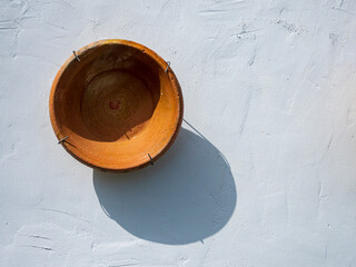 Plato decorativo de barro colgado en una pared típica andaluza.