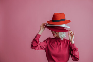 Happy smiling woman hides her face under many hapy. Funny posing model. Fashion, shopping, sale,...