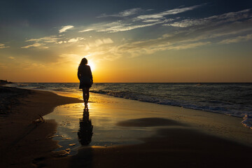 Sunset, sunrise and silhouette of a girl on the calm sea